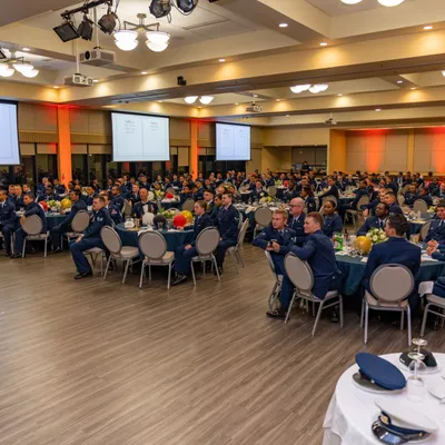 Uniformed airmen seated at tables in a banquet hall